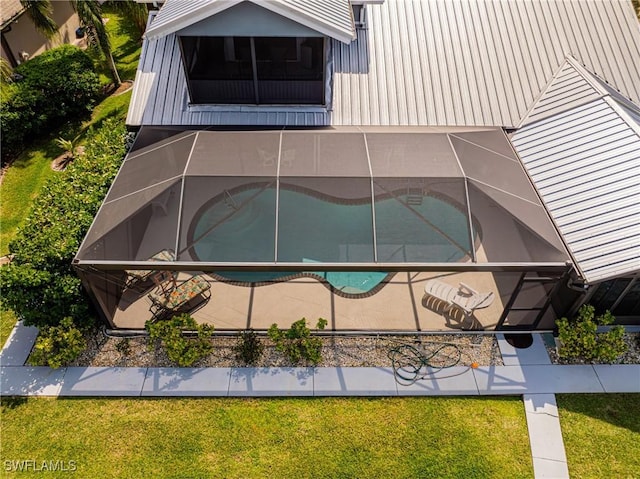 exterior space featuring glass enclosure and a yard