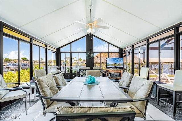 sunroom featuring tile patterned flooring, lofted ceiling, and a wall of windows