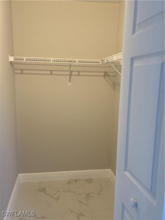 4430 18th Ave NE, Naples, FL 34120 - walk in closet featuring marble finish floor