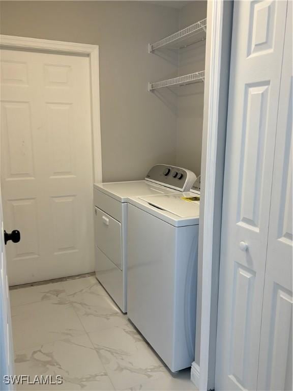 4430 18th Ave NE, Naples, FL 34120 - washroom with laundry area, marble finish floor, and washing machine and clothes dryer