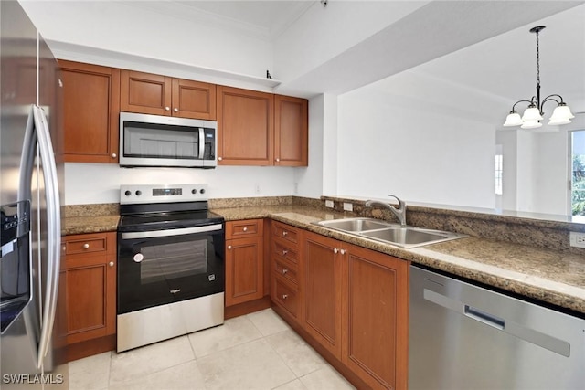 kitchen with a notable chandelier, ornamental molding, a sink, appliances with stainless steel finishes, and brown cabinetry