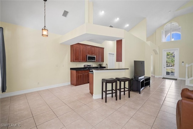 9954 Alabama St, Bonita Springs, FL 34135 - kitchen with a breakfast bar, light tile patterned flooring, appliances with stainless steel finishes, dark countertops, and open floor plan