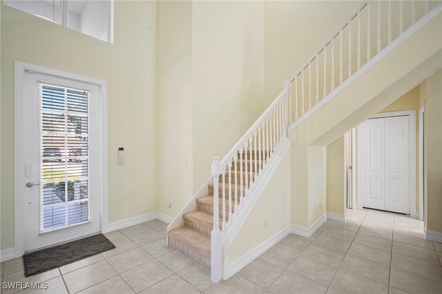 9954 Alabama St, Bonita Springs, FL 34135 - foyer with baseboards, a towering ceiling, stairs, and tile patterned flooring