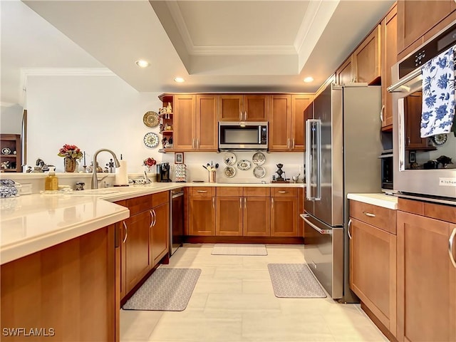 kitchen featuring ornamental molding, a sink, stainless steel appliances, light countertops, and a raised ceiling