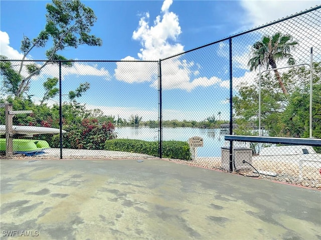 exterior space with a water view and fence