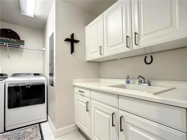 laundry area featuring washer and dryer, cabinet space, baseboards, and a sink