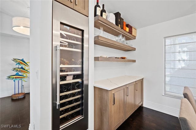 bar with wine cooler, baseboards, and dark wood-type flooring