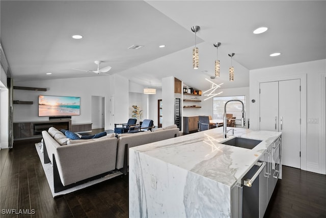 kitchen with decorative light fixtures, lofted ceiling, a sink, and dark wood-style floors