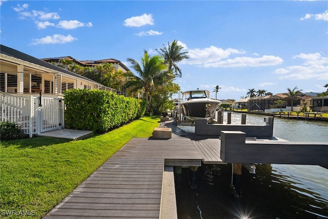 view of dock featuring a yard, a residential view, and a water view