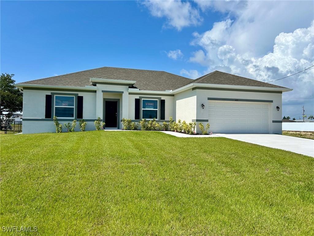 4321 NW 34th Ter, Cape Coral, FL 33993 - view of front of home with stucco siding, driveway, a garage, and a front yard
