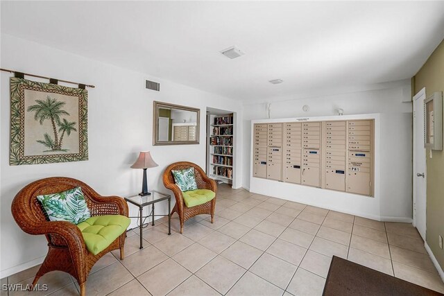 4200 Belair Ln Unit 303, Naples, FL 34103 - living area with built in shelves, baseboards, visible vents, mail area, and tile patterned floors