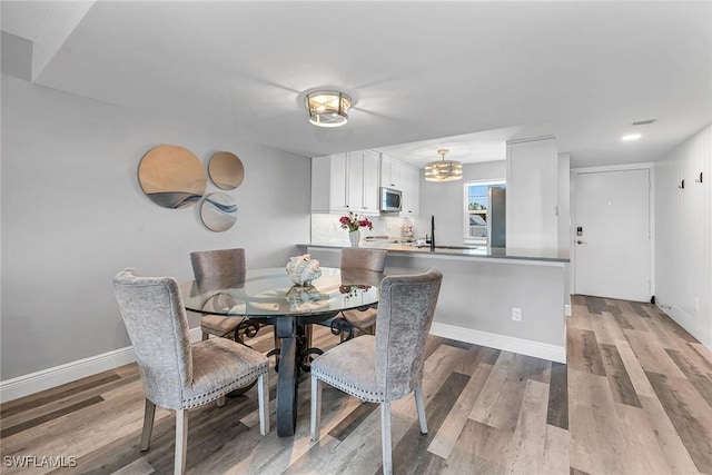 4200 Belair Ln Unit 303, Naples, FL 34103 - dining room with light wood finished floors, a notable chandelier, visible vents, and baseboards