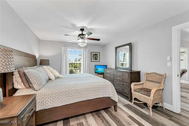 4200 Belair Ln Unit 303, Naples, FL 34103 - bedroom with baseboards, wood finished floors, and a ceiling fan
