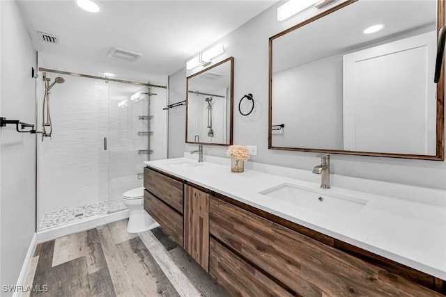 4200 Belair Ln Unit 303, Naples, FL 34103 - full bath featuring visible vents, toilet, a stall shower, a sink, and wood finished floors