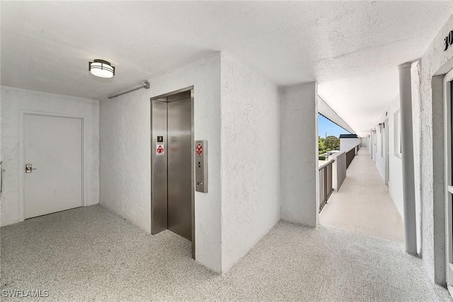 4200 Belair Ln Unit 303, Naples, FL 34103 - hall featuring elevator, a textured ceiling, and a textured wall