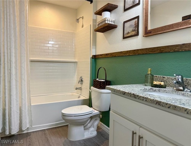 full bathroom featuring shower / bath combo with shower curtain, toilet, wood finished floors, vanity, and a textured wall