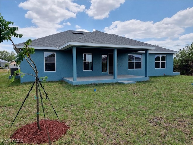 1127 NW 14th Ter, Cape Coral, FL 33993 - back of property featuring stucco siding, roof with shingles, and a lawn