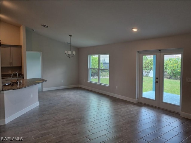 1127 NW 14th Ter, Cape Coral, FL 33993 - unfurnished dining area with a sink, baseboards, vaulted ceiling, recessed lighting, and a chandelier
