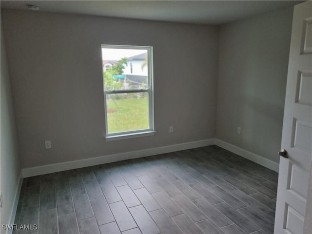 1127 NW 14th Ter, Cape Coral, FL 33993 - unfurnished room featuring baseboards, dark wood-type flooring, and a smoke detector