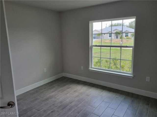 1127 NW 14th Ter, Cape Coral, FL 33993 - unfurnished room with baseboards and dark wood-style flooring
