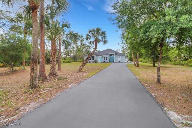 2312 4th Ave SE, Naples, FL 34117 - view of front of house featuring aphalt driveway, a front yard, and a garage