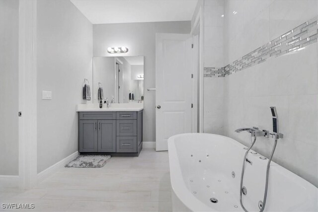 2312 4th Ave SE, Naples, FL 34117 - bathroom featuring vanity, baseboards, and a tub with jets