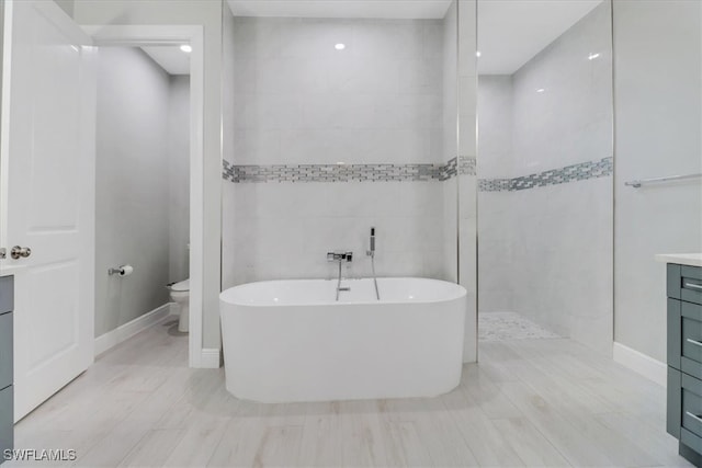 2312 4th Ave SE, Naples, FL 34117 - bathroom featuring a freestanding tub, tile walls, toilet, a walk in shower, and vanity