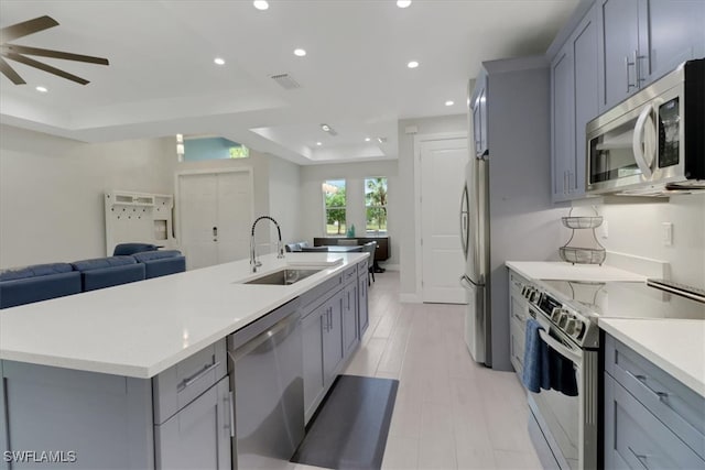 2312 4th Ave SE, Naples, FL 34117 - kitchen featuring a sink, open floor plan, a tray ceiling, stainless steel appliances, and gray cabinets