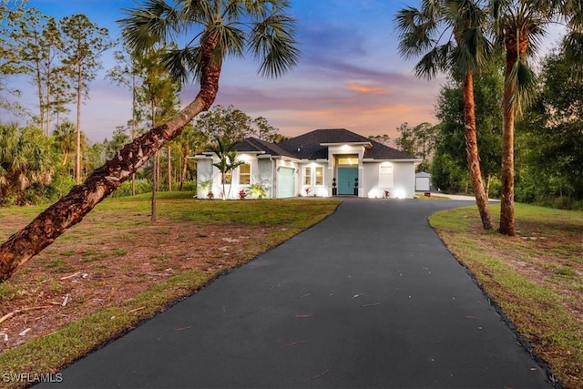 2312 4th Ave SE, Naples, FL 34117 - view of front facade featuring a yard, a garage, driveway, and stucco siding