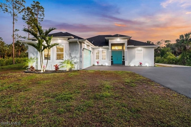 2312 4th Ave SE, Naples, FL 34117 - prairie-style house with aphalt driveway, a front yard, stucco siding, and an attached garage