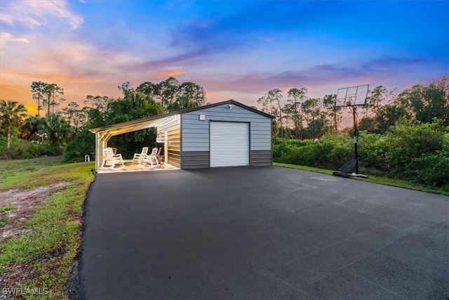 2312 4th Ave SE, Naples, FL 34117 - garage at dusk featuring a garage, a carport, and driveway