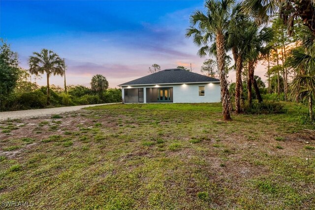 2312 4th Ave SE, Naples, FL 34117 - back of house at dusk featuring a yard and stucco siding