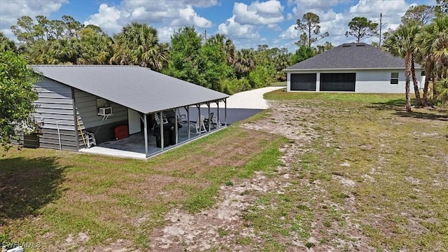 2312 4th Ave SE, Naples, FL 34117 - view of yard with a sunroom, driveway, and a garage