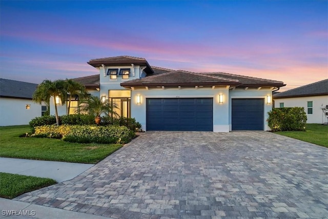 3721 Sapphire Cove Cir, Naples, FL 34114 - prairie-style house featuring a garage, decorative driveway, stucco siding, a front yard, and a tile roof
