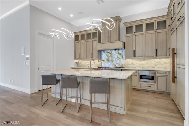 3721 Sapphire Cove Cir, Naples, FL 34114 - kitchen featuring a chandelier, a sink, decorative backsplash, light wood-style floors, and light countertops