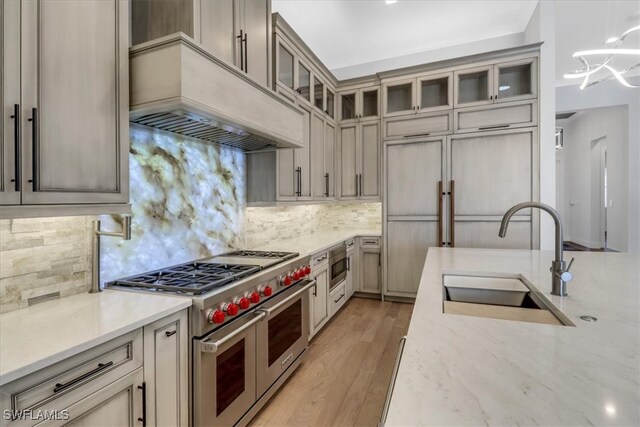 3721 Sapphire Cove Cir, Naples, FL 34114 - kitchen featuring stainless steel appliances, custom range hood, a sink, and backsplash