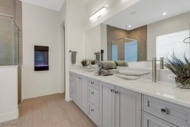 3721 Sapphire Cove Cir, Naples, FL 34114 - bathroom featuring a shower stall, double vanity, baseboards, and tile patterned floors