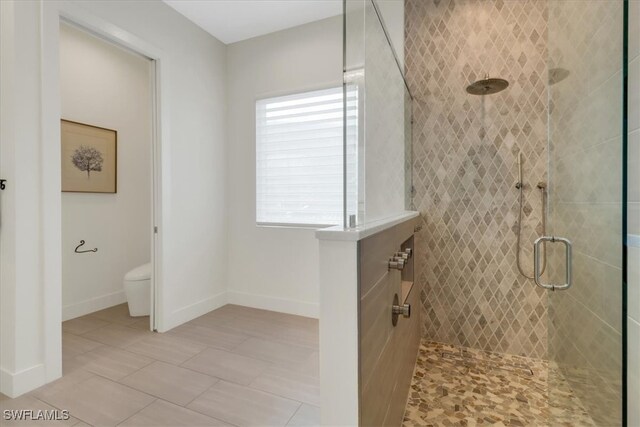 3721 Sapphire Cove Cir, Naples, FL 34114 - full bathroom with a shower stall, toilet, baseboards, and tile patterned flooring