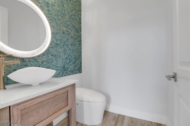 3721 Sapphire Cove Cir, Naples, FL 34114 - half bathroom with toilet, vanity, wood finished floors, and baseboards
