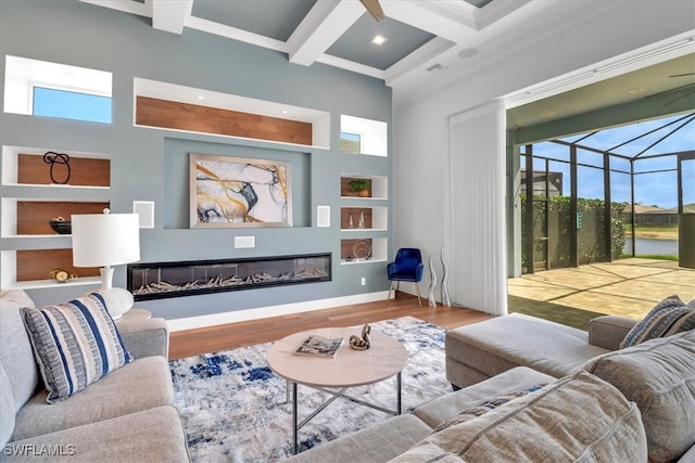 3721 Sapphire Cove Cir, Naples, FL 34114 - living area with healthy amount of natural light, wood finished floors, coffered ceiling, beam ceiling, and a glass covered fireplace