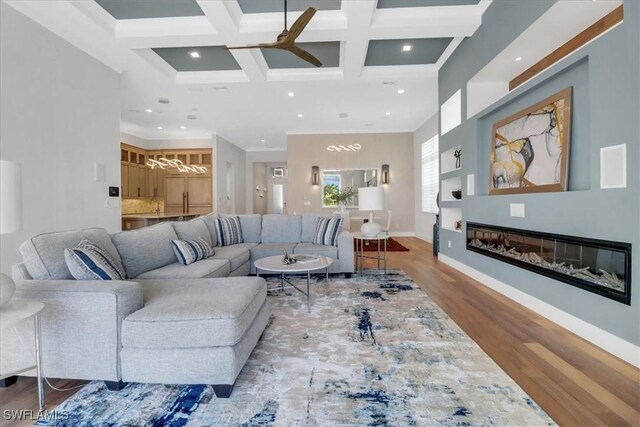 3721 Sapphire Cove Cir, Naples, FL 34114 - living room with a ceiling fan, wood finished floors, beamed ceiling, a glass covered fireplace, and coffered ceiling