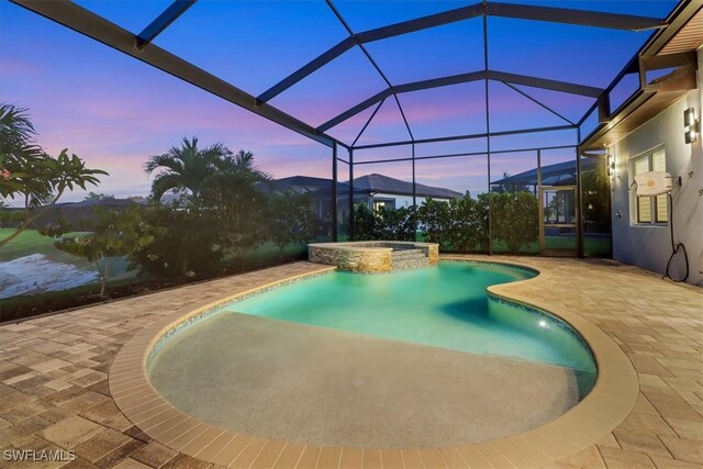 3721 Sapphire Cove Cir, Naples, FL 34114 - pool at dusk featuring a patio, a pool with connected hot tub, and a lanai