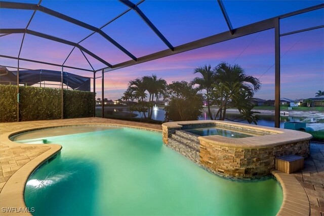 3721 Sapphire Cove Cir, Naples, FL 34114 - pool at dusk featuring a pool with connected hot tub, a water view, and a lanai