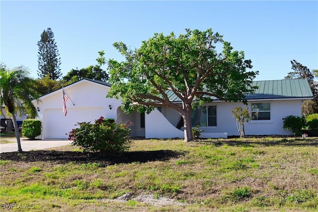 view of front of home featuring a front lawn, concrete driveway, stucco siding, and an attached garage