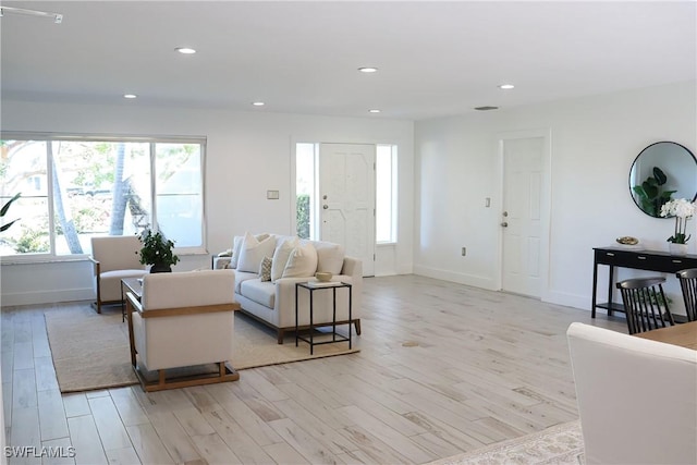 living room with baseboards, recessed lighting, and light wood-style floors