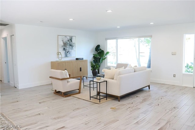 living room with baseboards, a healthy amount of sunlight, recessed lighting, and light wood finished floors