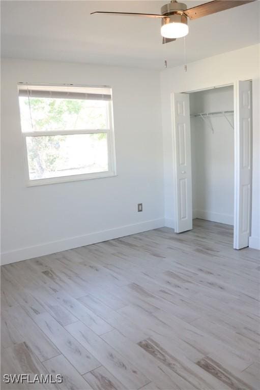 unfurnished bedroom featuring baseboards, a closet, a ceiling fan, and light wood finished floors