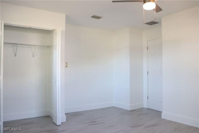 unfurnished bedroom featuring a ceiling fan, baseboards, a closet, and light wood finished floors