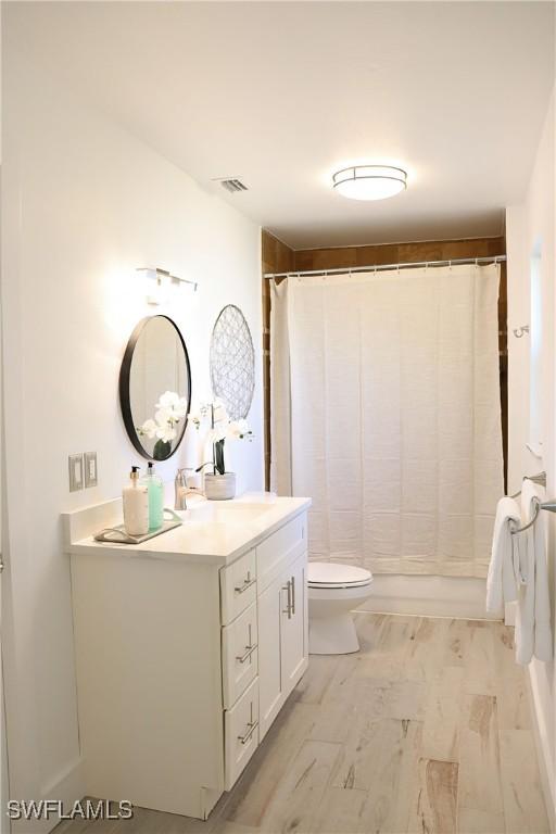full bathroom with visible vents, toilet, vanity, and a shower with shower curtain