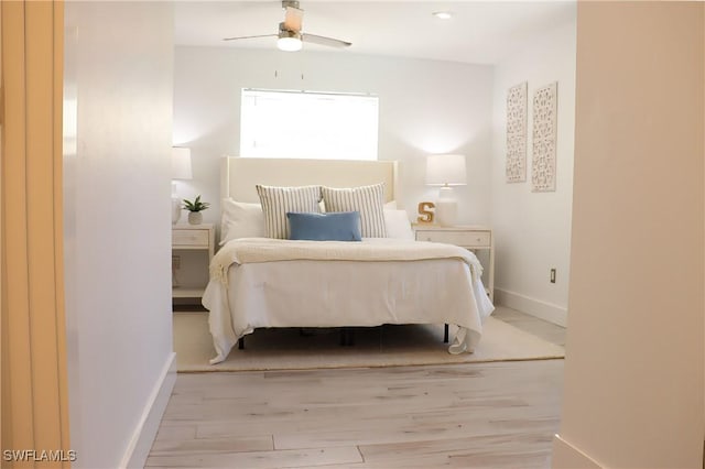 bedroom with baseboards, wood finished floors, and a ceiling fan